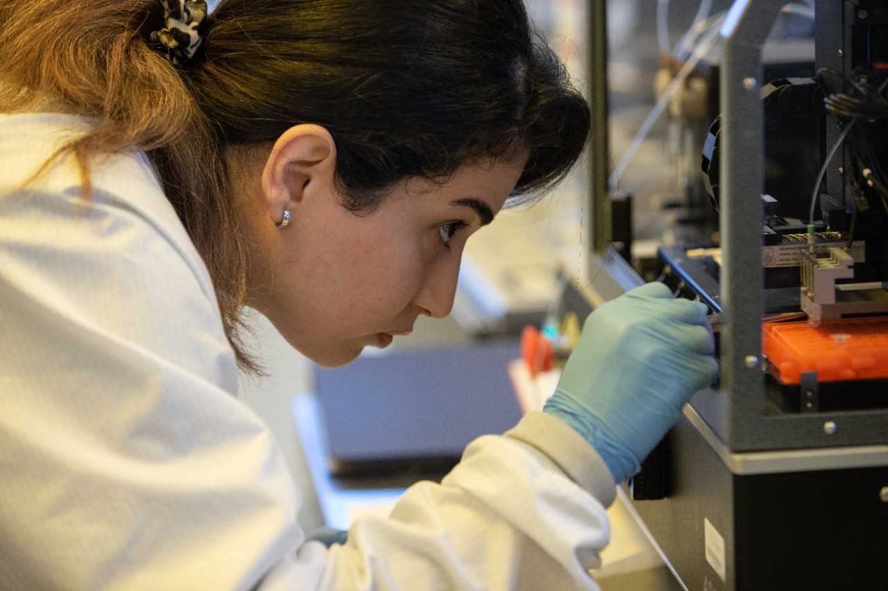 Shima Dalirirad adjusts a machine that prints test strips in UC's Nanoelectronics Laboratory.