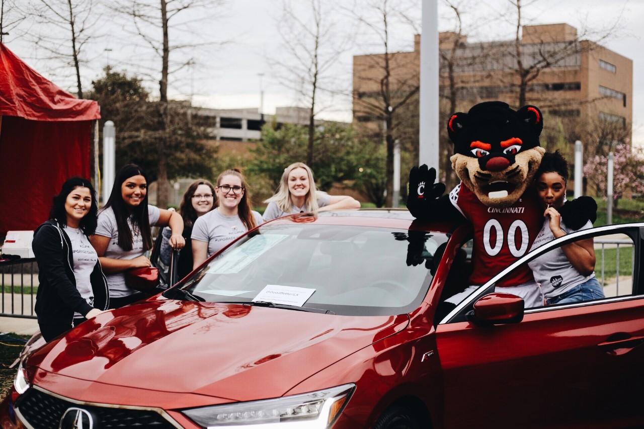 Students and the Bearcat gather around a car
