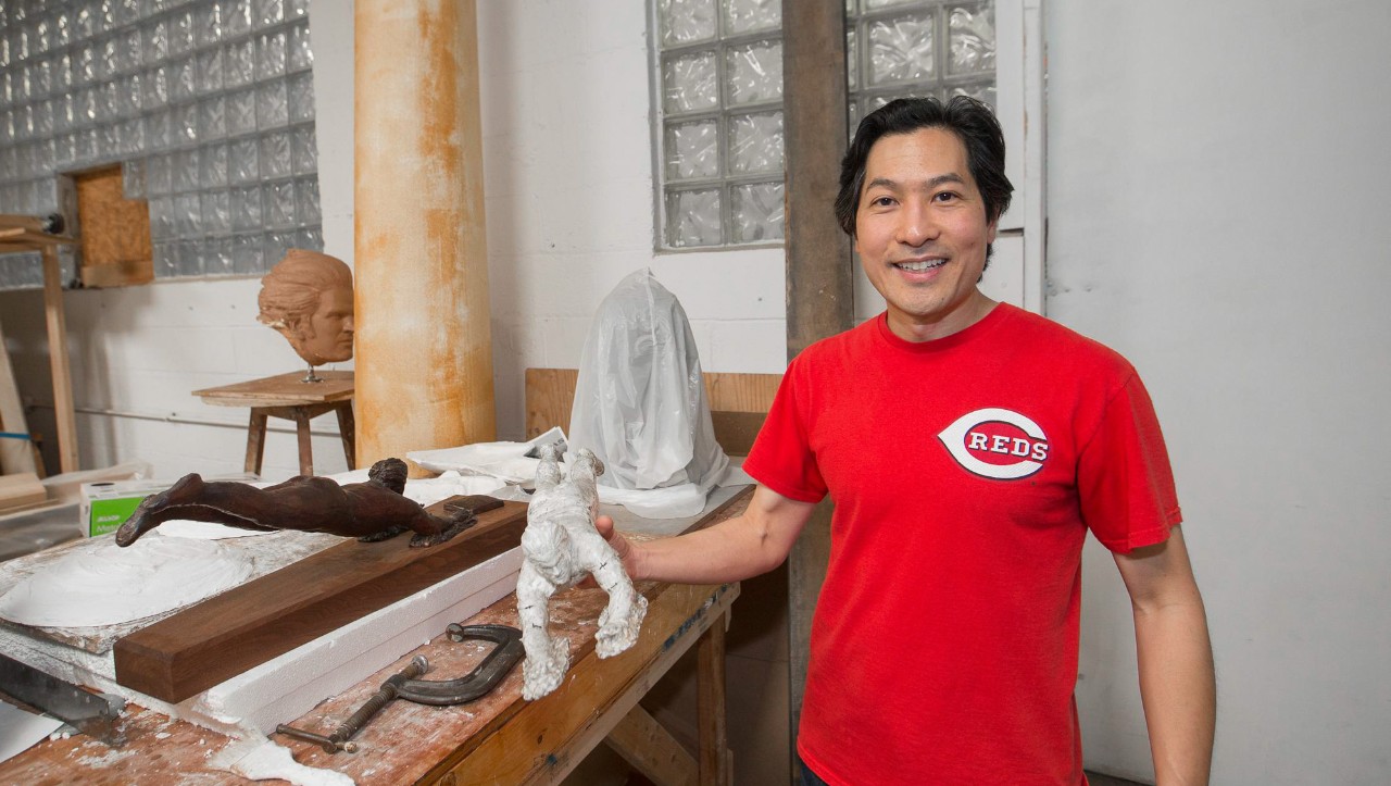 Artist Tom Tsuchiya works with a clay portrait of a Red Stockings player in his studio