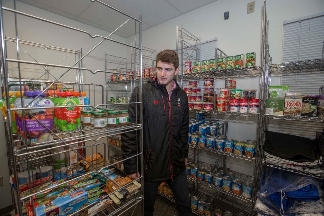 A UC student stocks the Bearcats Pantry shelves.