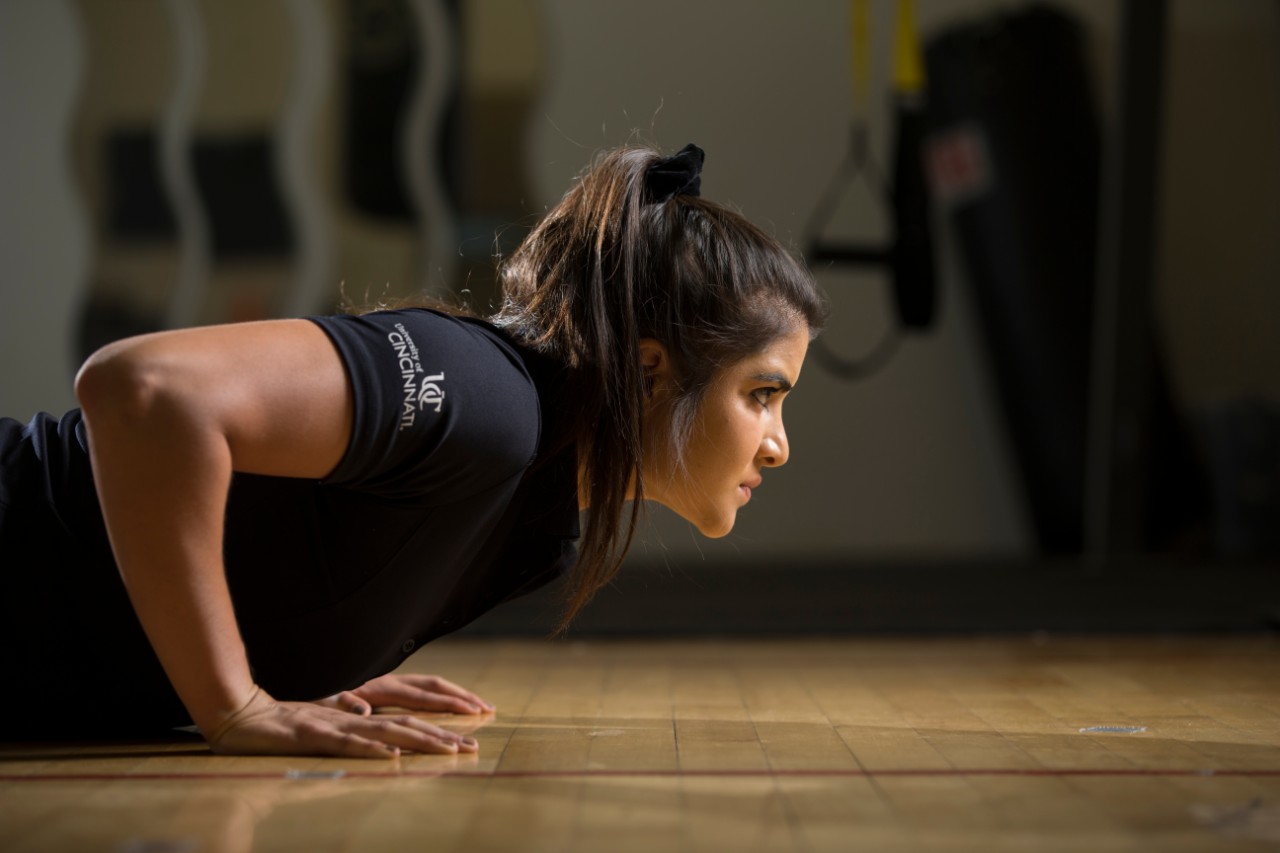 A student does a push-up in a gym.