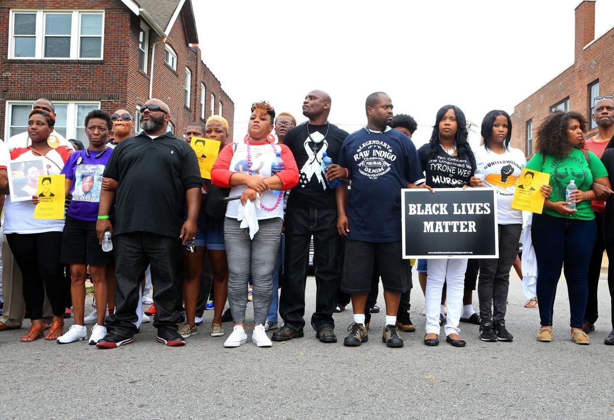 protestors stand in a line holding signs saying "black lives matter"