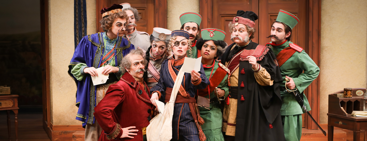 Actors in character gathered around a mailed letter in CCM's production of "The Government Inspector."