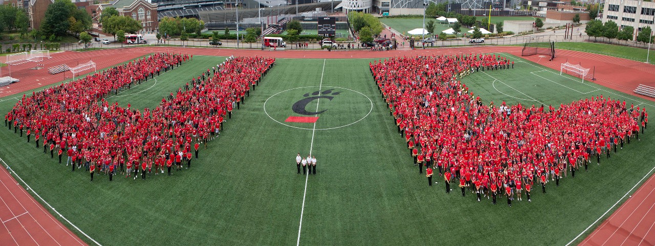 Thousands of students in red form the letters "UC" on a soccer field