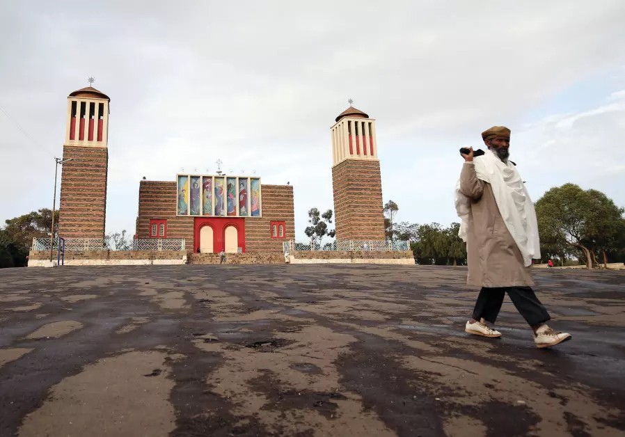 a man walks across a parking lot in front of a mosque