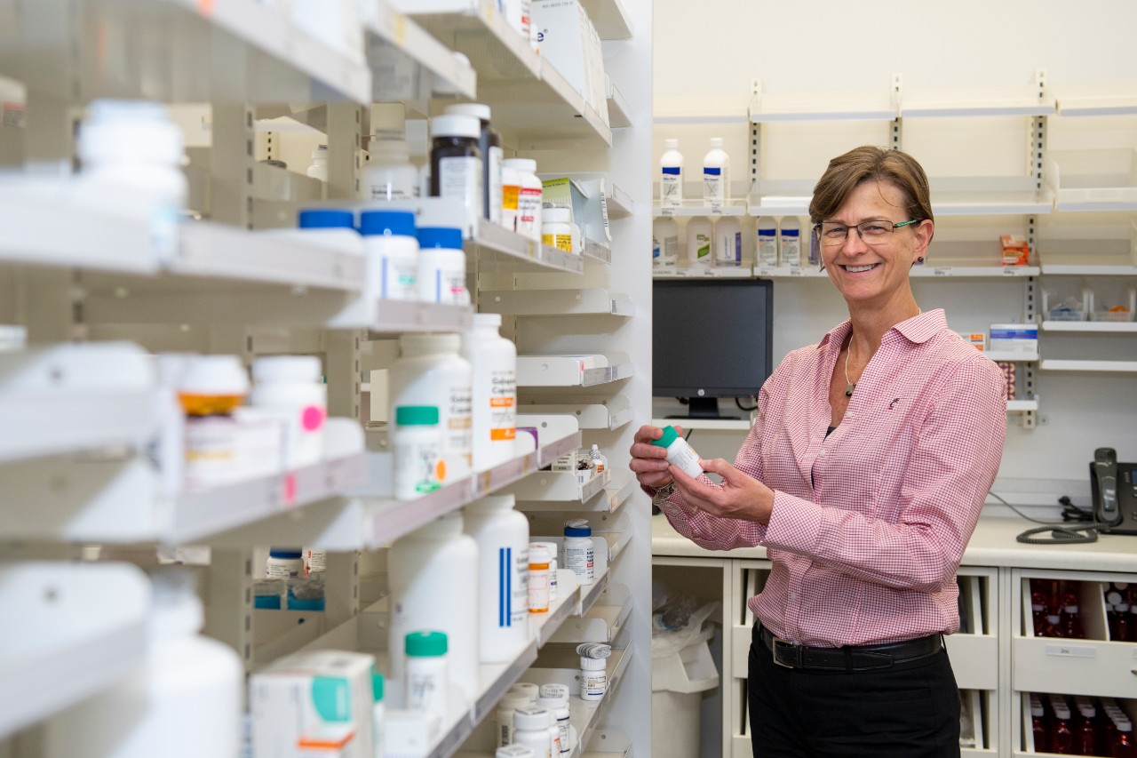 Pharmacy faculty member Bethanne Brown, PharmD, in a pharmacy setting holding a bottle of pills.