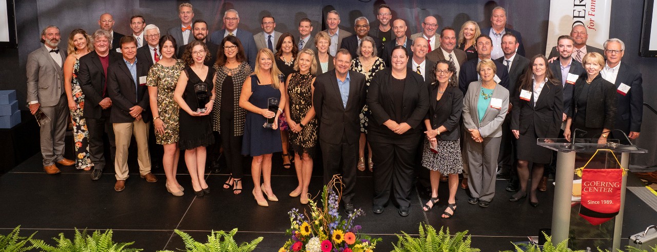 A crowd of the winners on stage posing for a photo at the 2019 awards event.