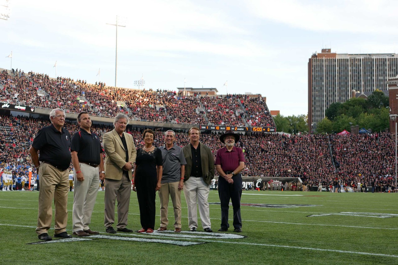 Honored on the field during the UC vs. UCLA football game were, from left to right, Gary Slater, Paul Orkwis, Rick Armstrong, Awatef Hamed, Ralph Spitzen, Mark Armstrong, and Tom Black. Photo/Corrie Stookey/CEAS Marketing