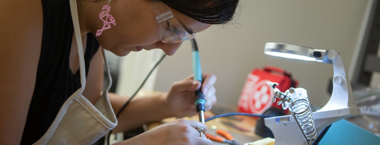 Close-up of a student using a soldering tool
