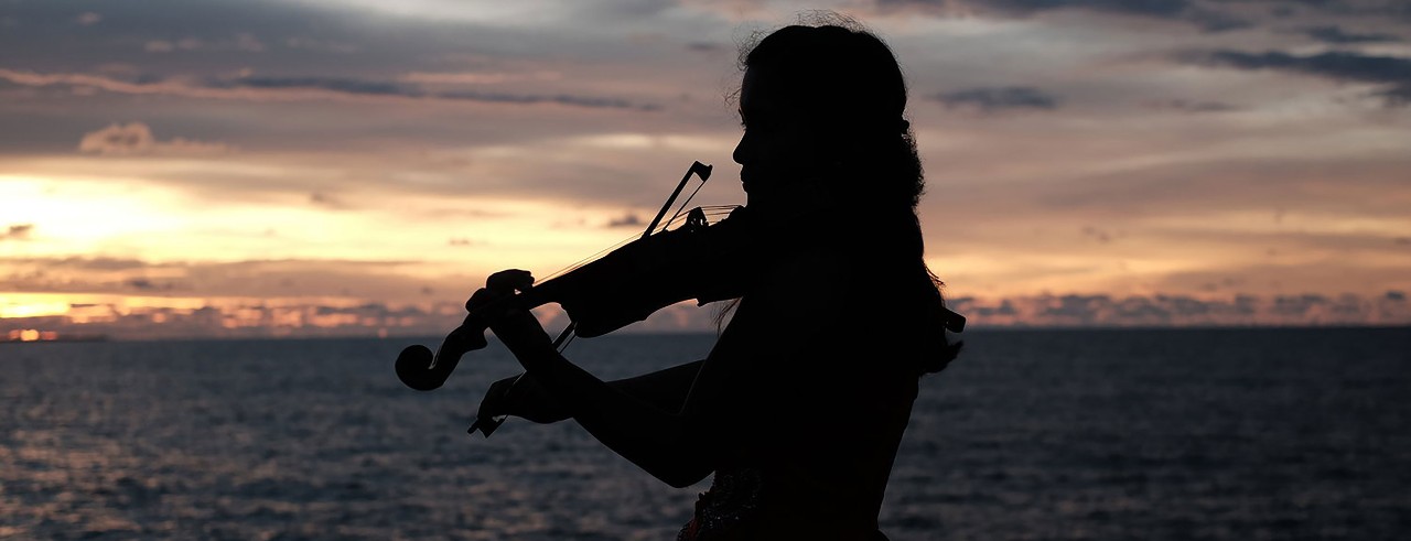 KayCee Galano practices her violin while at the beach