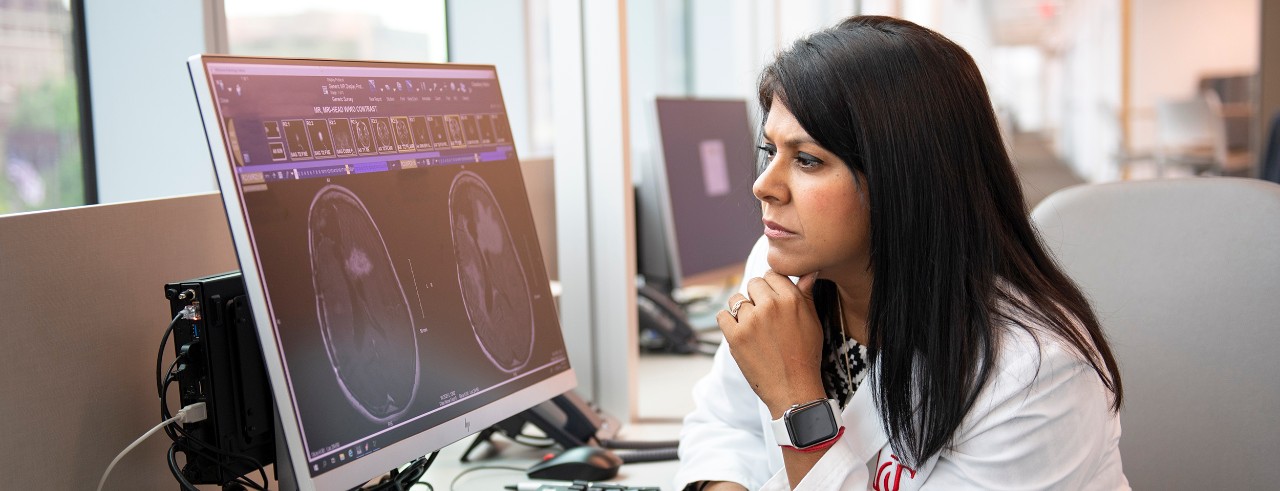 Doctor in lab coat looks at brain scan