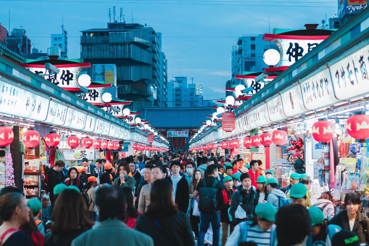 A crowded street market in Tokyo, Japan, at dusk. 
