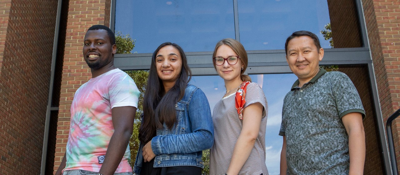 Four students pose in a line