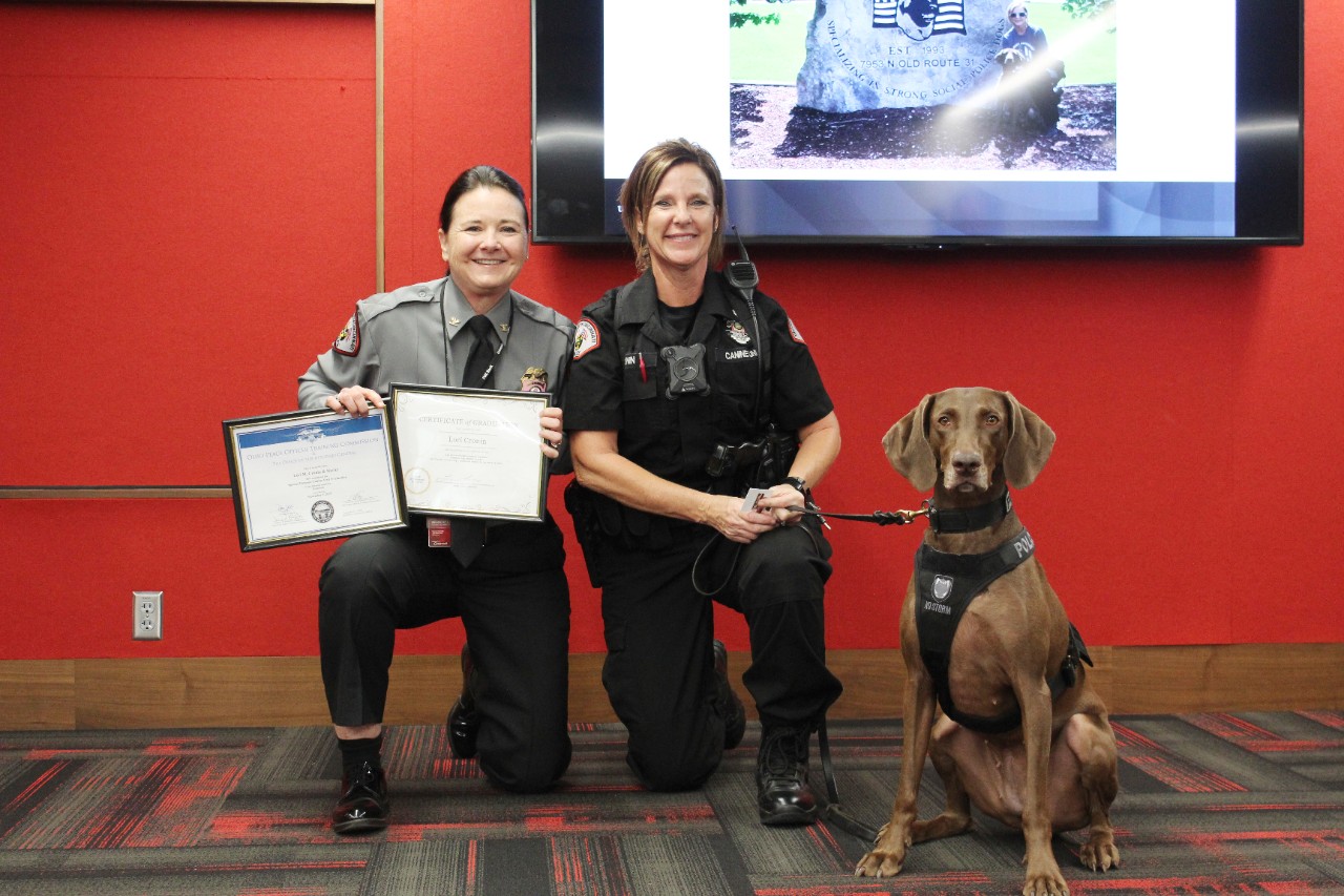 UCPD Chief Maris Herold poses with Officer Lori Cronin and K9 Harley.