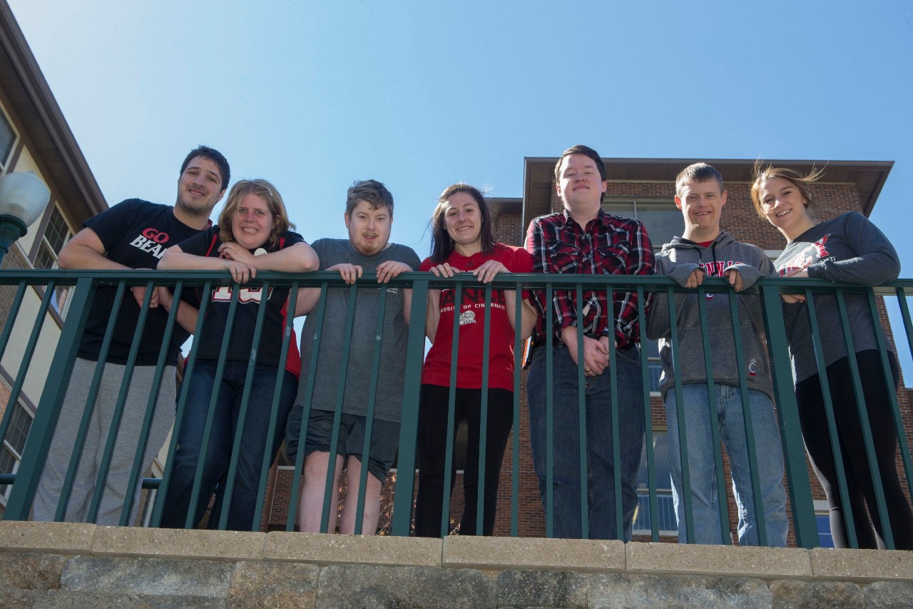seven students looking down from a balcony