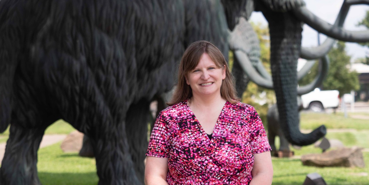 Farrington poses in front of a mammoth sculpture.