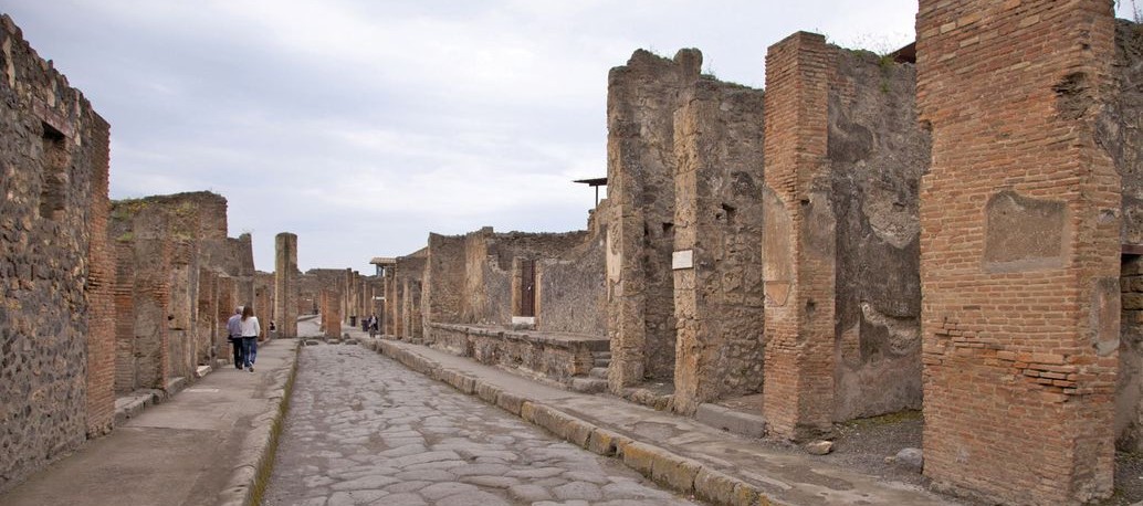 Ancient ruins line a crumbling sidewalk