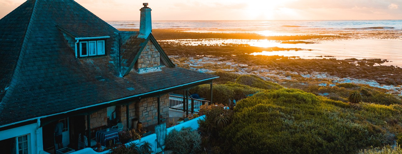 Cottage by body of water with sunset