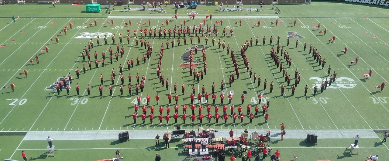 The UC Alumni Marching Band creates an outline of the number 200 with their bodies