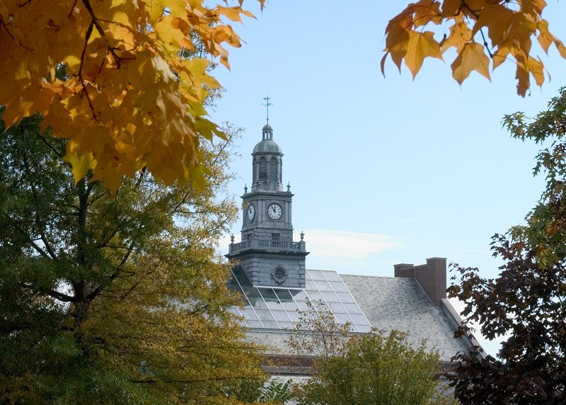 Photo of McMicken hall, seen through fall tree leaves