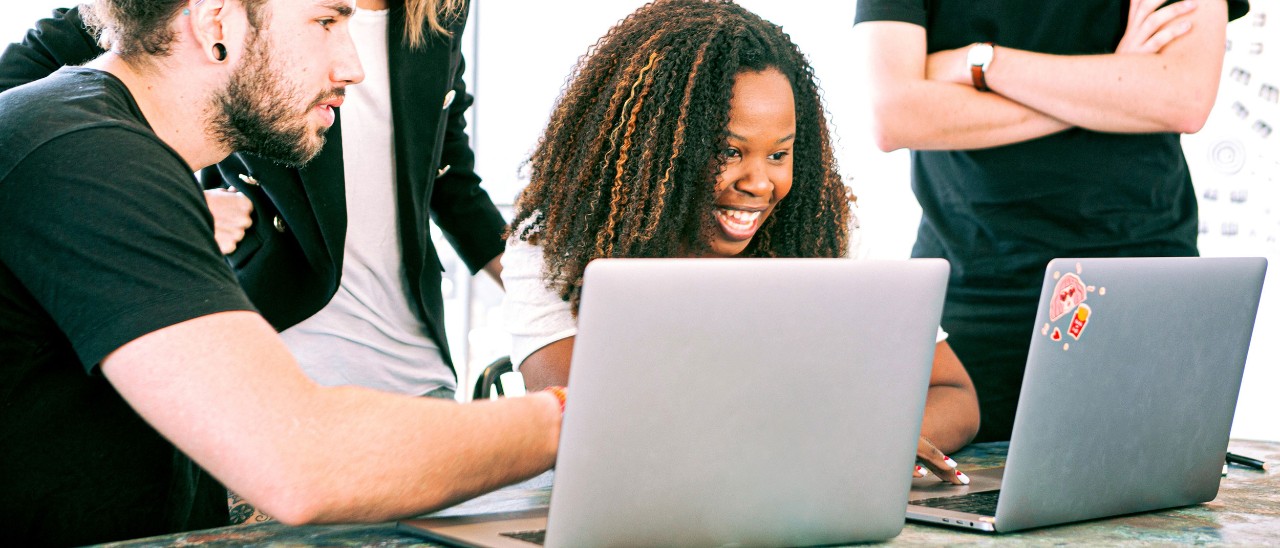 a group of professionals collaborating around laptops