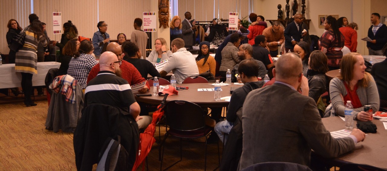 People sitting at tables at presentation in banquet room.