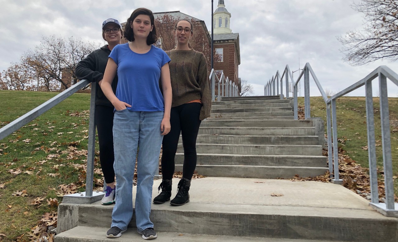 Students in Bob Hyland and Susanna Tong's bird diversity group (Mickaela Mohr, Emily Noeske and Zoe Gordon) pose in front of the steps connecting McMicken to Clifton Court. 