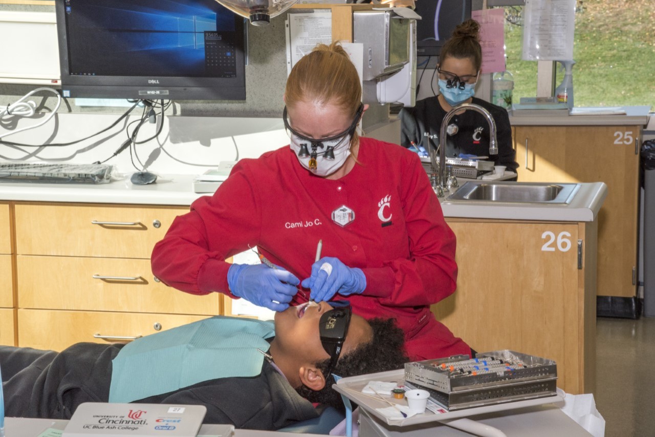 dental hygiene student works with patient 