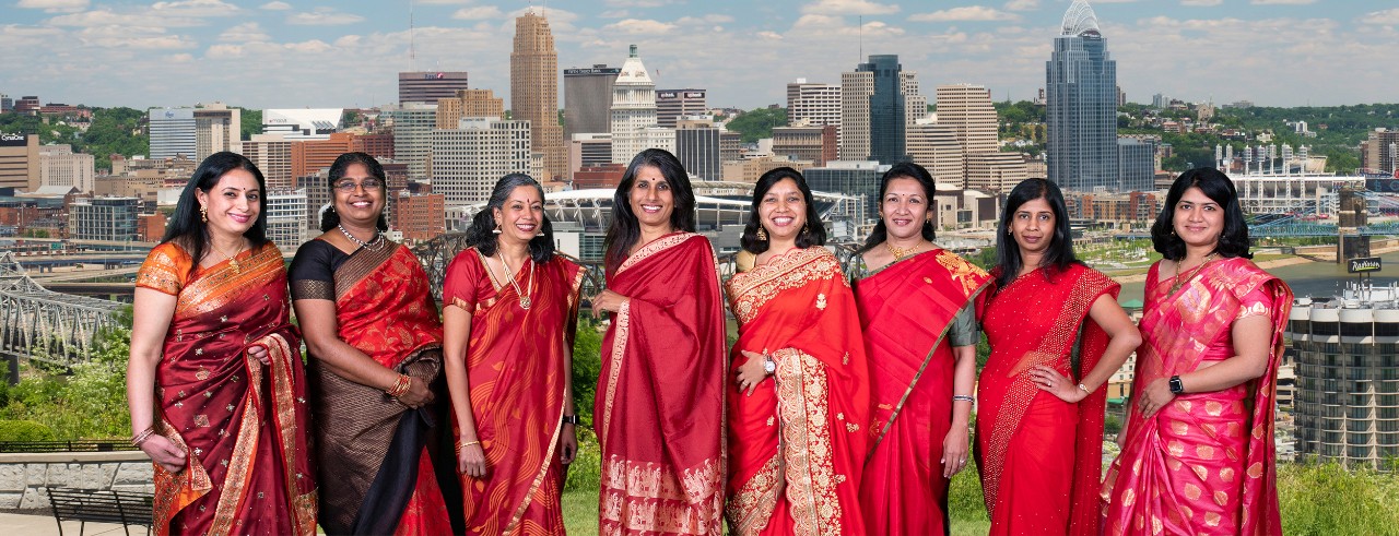 Image of eight women dressed in Red Sarees.