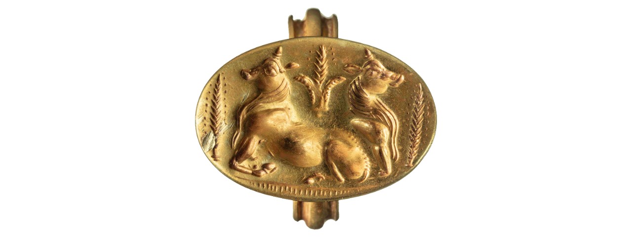 A gold ring features an iconic image of two bulls amid sheaves of barley.