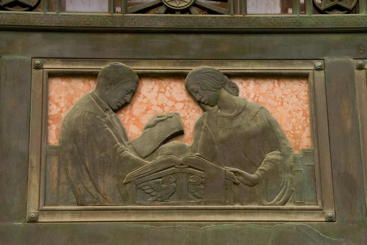 A bas relief above a door at Blegen Library depicts scholars at work.