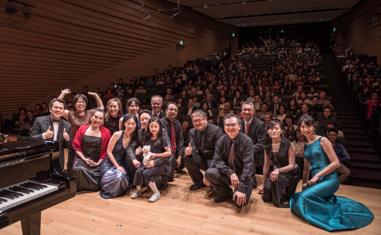 Alumni performers pose on stage in front of a full house at the Eslite Performance Hall in Taipei City, Taiwan.