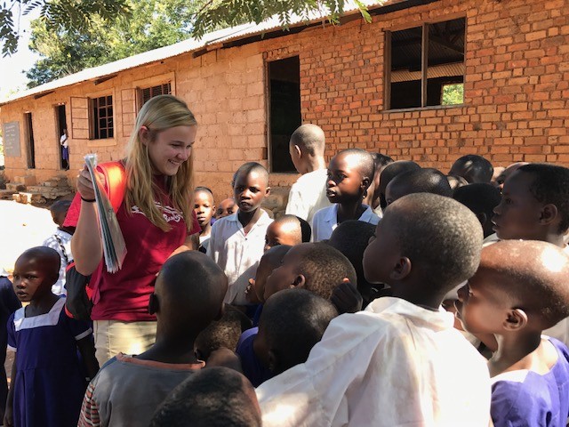 UC student talks with children in Tanzania.