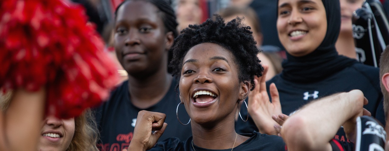 UC students celebrate during a UC football game. 