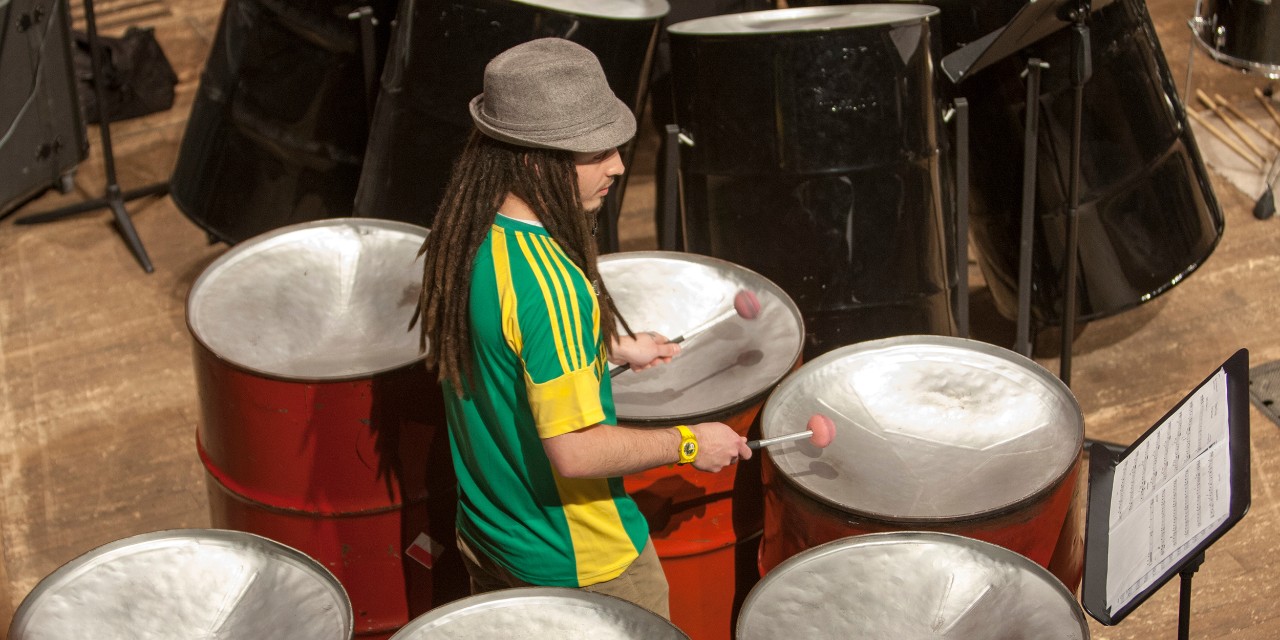 CCM student playing on cans during a steel drum band concert.