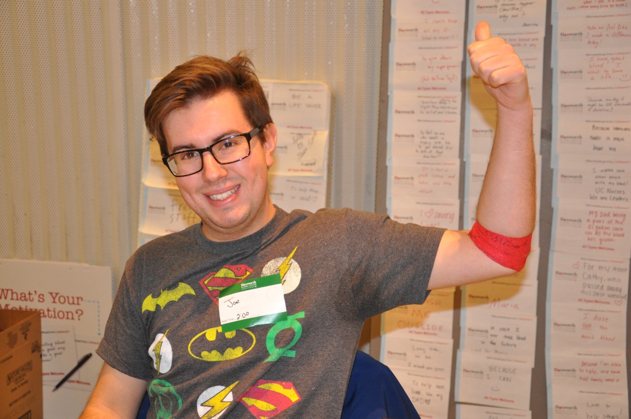 Donor at UC Blood Drive showing off red arm bandage after donating