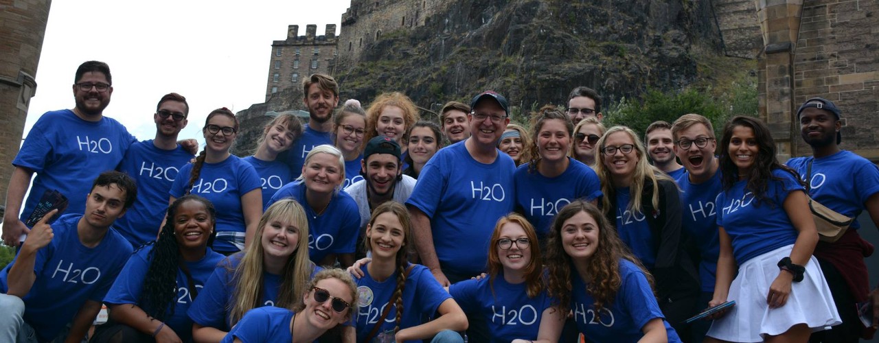 Students in Richard Hess's study abroad program take a group photo in front of a Scottish castle.