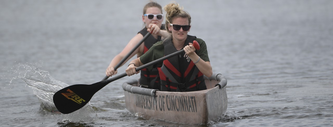 UC students race their concrete canoe on a lake as part of a civil engineering competition.
