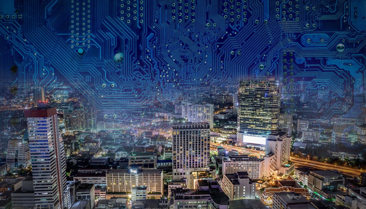 A colorful nighttime view of an urban area with circuitboard patterns overlaid