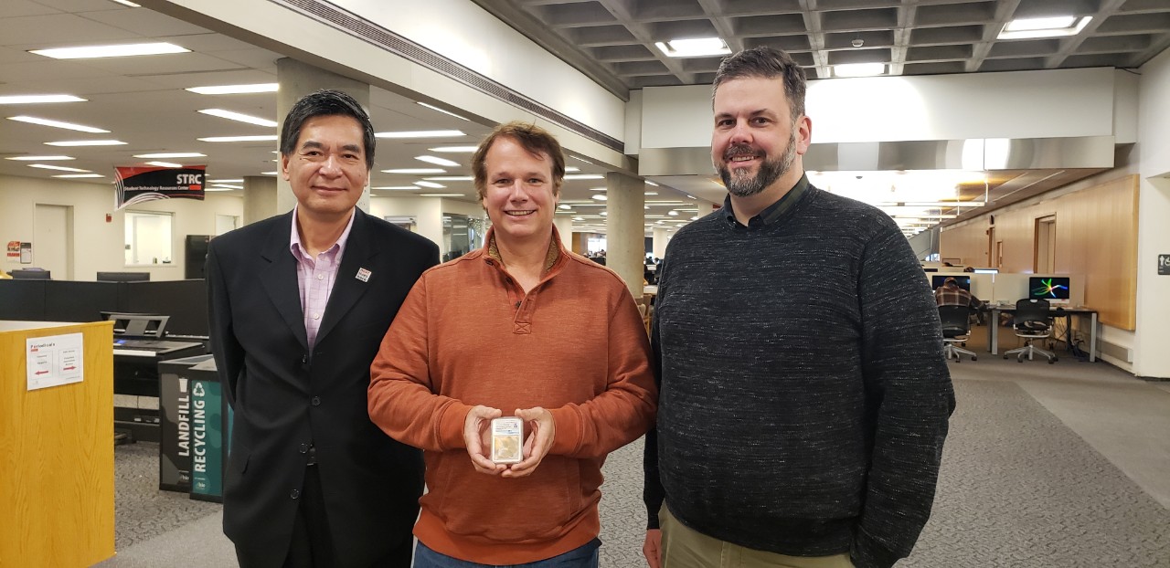 three men with piece of fabric from Wright brothers