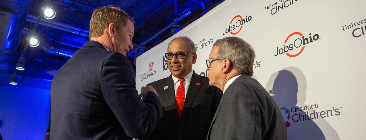 Lt. Gov. Jon Husted, UC President Neville Pinto and Ohio Gov. Mike DeWine on the podium at the 1819 Innovation Hub