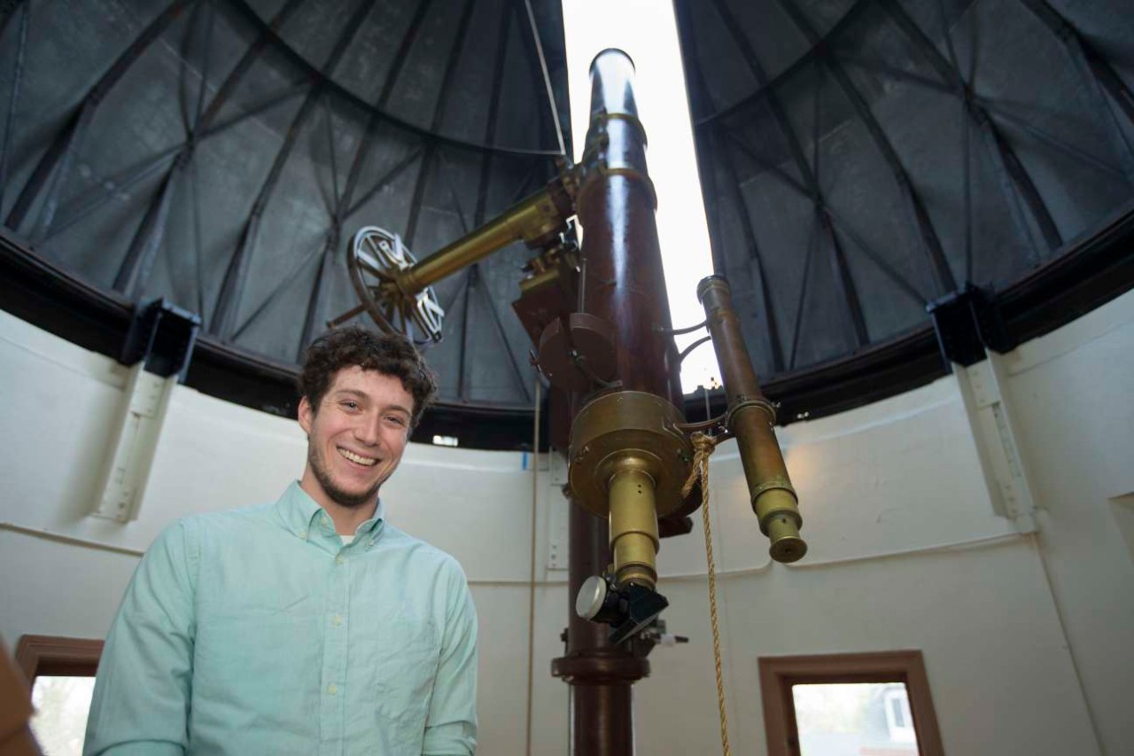 Kevin Wagner poses in front of a historic telescope at the Cincinnati Observatory.