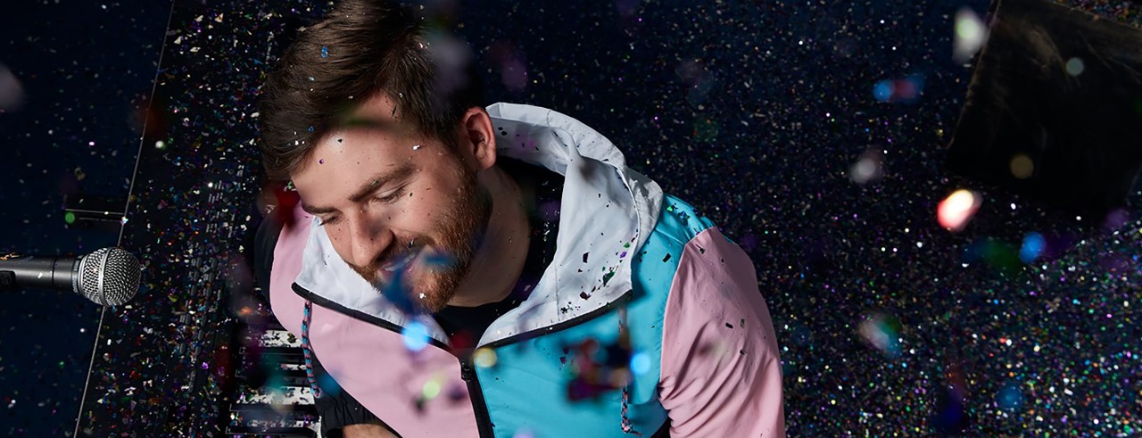 Ryan Fine at the piano with confetti falling from the ceiling