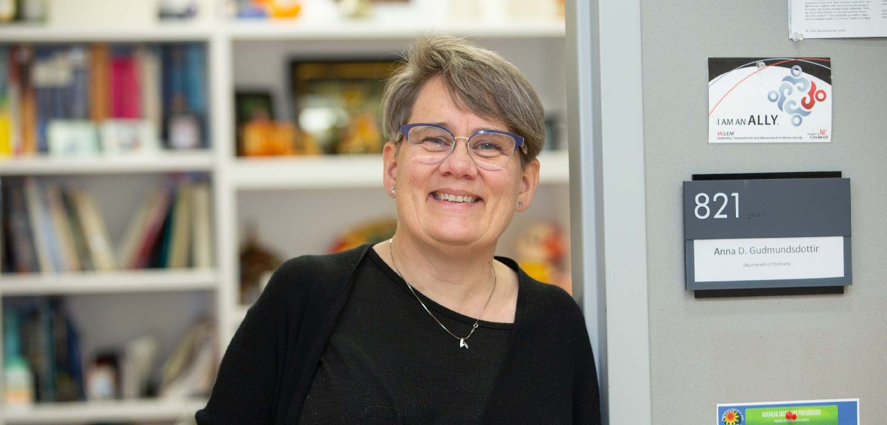 Anna Gudmundsdottir poses in front of a bookcase in her office.