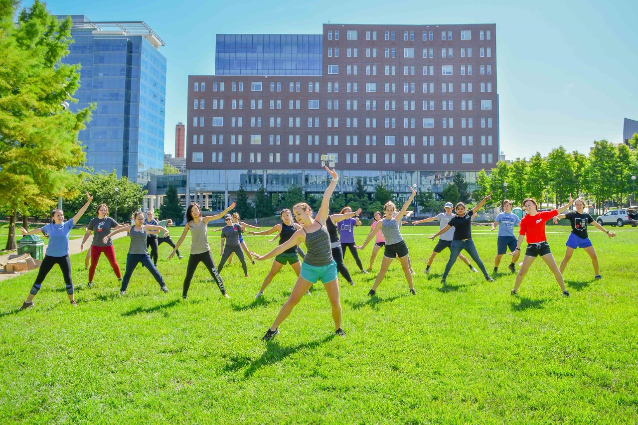 Students participating in a yoga class on the Campus Green