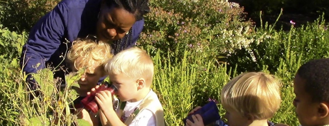 Children play outside with binoculars.