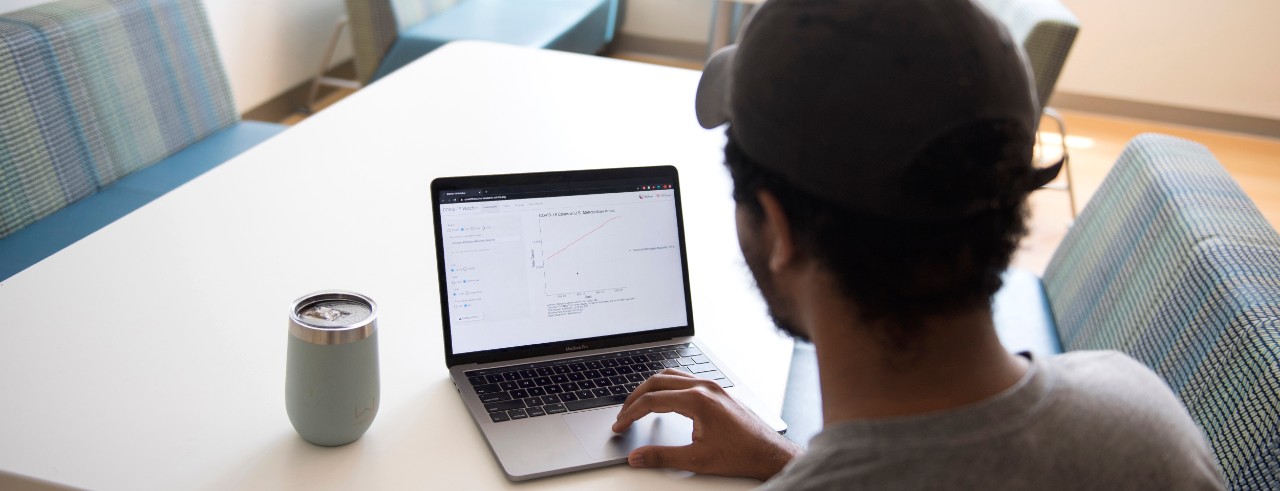  men looks at laptop showing interactive dashboard