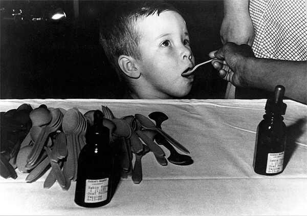A child receives a dose of live oral polio vaccine from a spoon in the 1960s.
