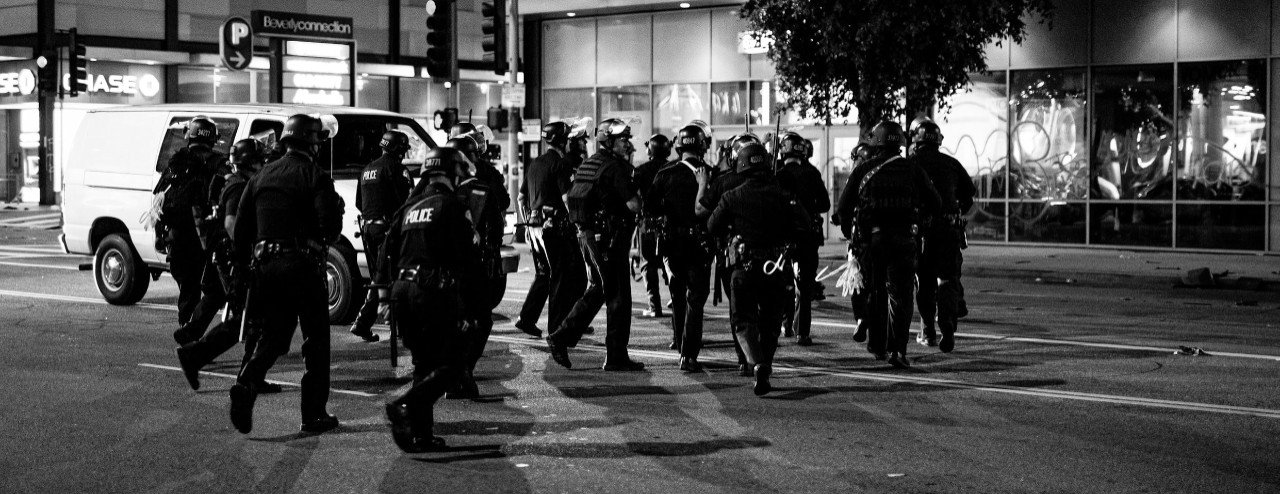 Police in riot gear respond to enforce a curfew.