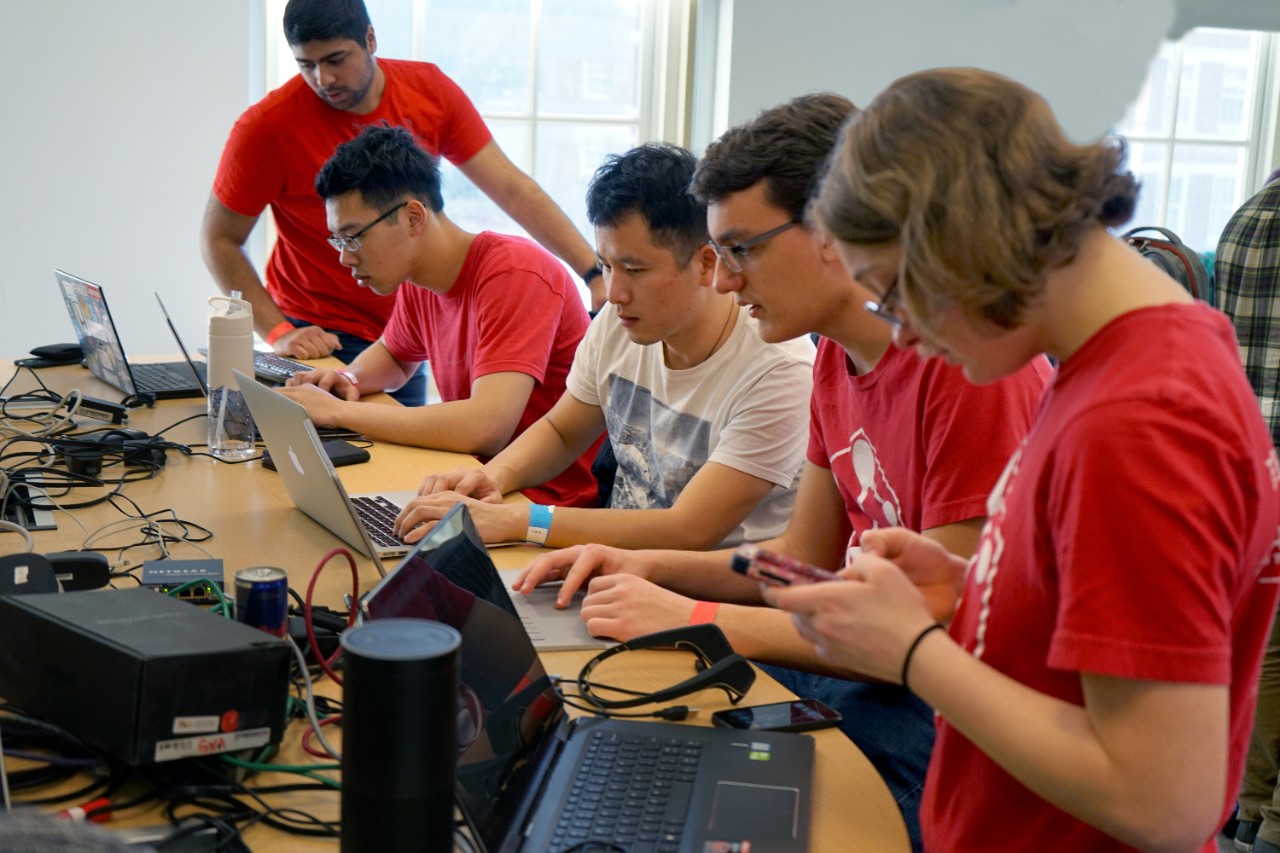 Group of students at hackathon event tinkering with technology 